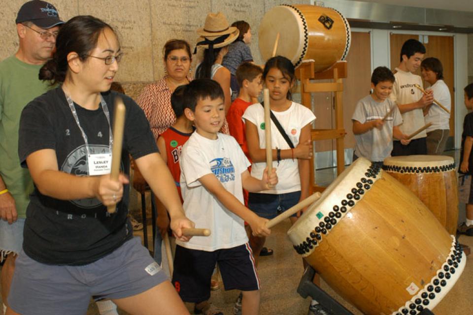 Lesley Handa demonstrates taiko for some children